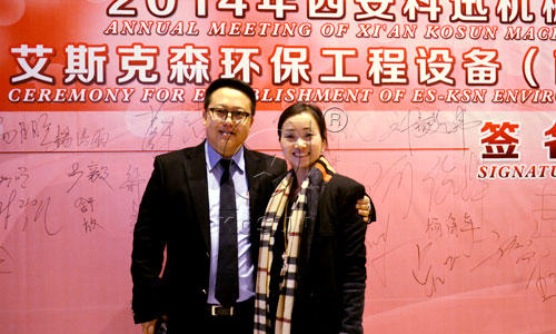 Photo of Mr Geng Feng, the general manager of KOSUN and his employee in front of signature wall