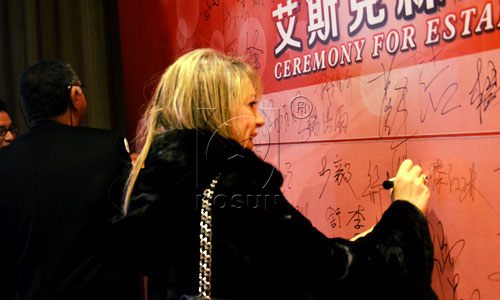 Ms Naella from ES Company signs her name on signature wall